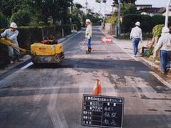 写真：舗装合材を敷き、転圧している様子