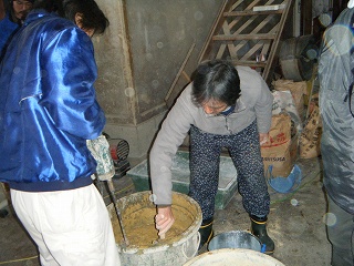 写真：原材料（藁スサや壁土用粉土など）を練り混ぜています