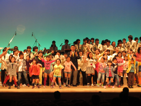 画像：県民会館のイベントの様子 壇上に大勢の子供達と知事1