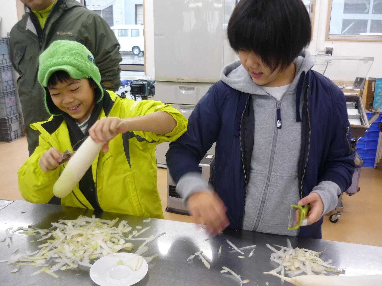 皮むき器で大根の皮をむく参加者たち