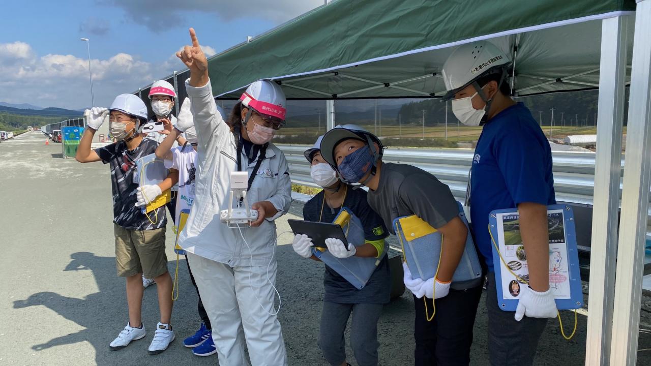 ドローンの行く手を見る小学生