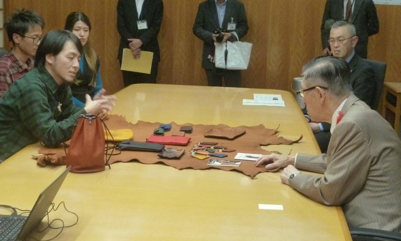 知事に熊皮製品を説明する山田さん