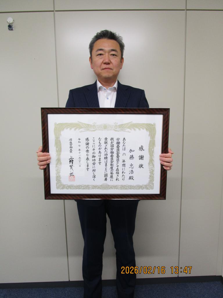 表彰された加藤氏が感謝状を両手に持っています。